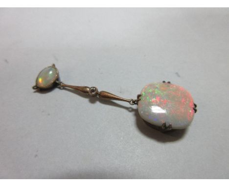 An early 20th century opal and diamond pendant, designed as a small oval opal cabochon, collet set horizontally with suspenso