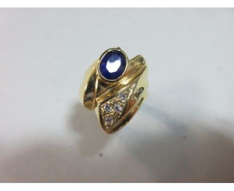 A contemporary sapphire and white hardstone ring, the oval cut royal blue sapphire collet set in an asymmetrical zigzag sweep