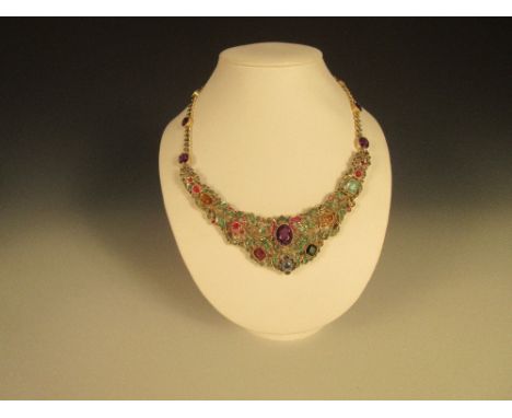 An Indian gem set and silver colarette necklace, of gorget form, the front pierced section of floral and foliate design set w