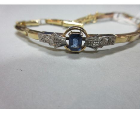 A sapphire and diamond bracelet, set to the front with an octagonal step cut light blue sapphire to epaulette shoulders set w