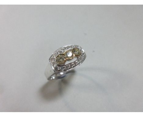 A yellow diamond and white diamond cluster ring, with a line of three round brilliant cut fancy light yellow diamonds collet 