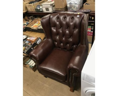 A large button back wing armchair and two valet stands