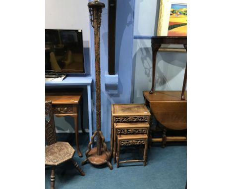 An Oriental carved nest of tables and a carved standard lamp