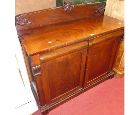 An early Victorian mahogany ledge back chiffonier, having twin cushion frieze drawers, over lower panelled cupboard doors, wi