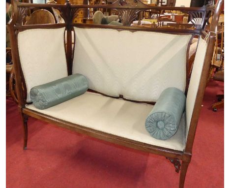 An Art Nouveau mahogany two-seater high back salon settee with pale green fabric inset upholstery and pierced floral detail, 
