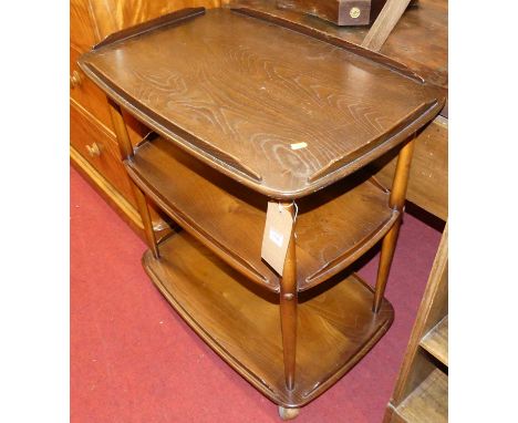 An Ercol dark elm three-tier tea trolley, raised on roller castors