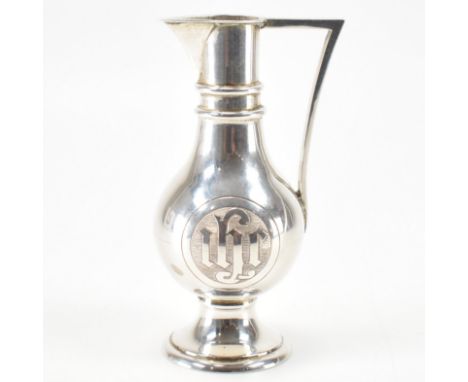 An Edwardian hallmarked silver water jug. The vessel raised on a flared foot with baluster form, doubly banded to the neck &a