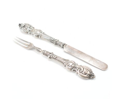 A 1930s George Unite silver hallmarked small knife and fork set. The set having scrolled handles with engraved foliate detail