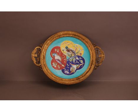 A late 19th century French Majolica ceramic dish with bird decoration, in a gilt metal mount with two handles raised on lion 