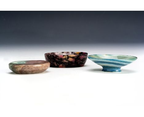 Three small carved far eastern vessels, comprising a Rhodonite example 6.5cm wide, together with a banded agate vessel on a f