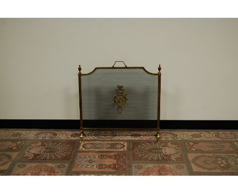 A Edwardian brass fire screen, with wreath and armorial to centre