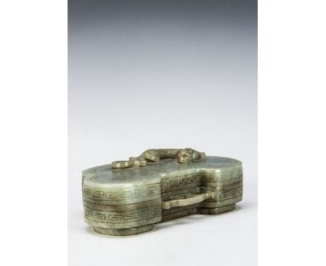 A 20th century carved jadeite jade kidney shaped box and lid, the id with a reclining mythical creature, raised on a footed b