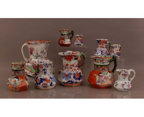 A collection of 19th century ceramic jugs, some by Masons, of differing sizes, the largest 26cm high, the shortest 7.5cm, AF 