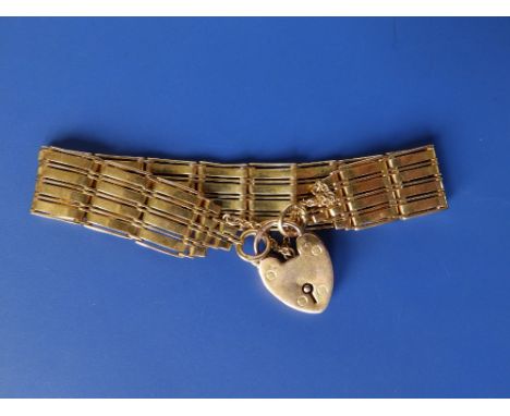 A yellow metal bracelet of solid gate link style with 9ct gold padlock clasp, 7.5".