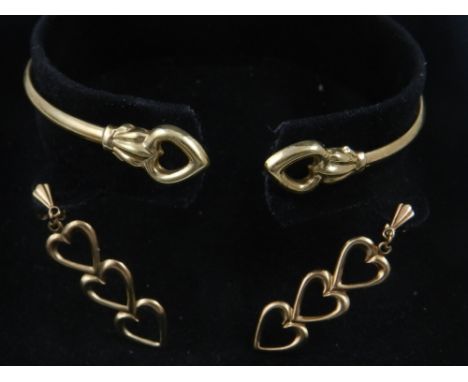 A 9 carat yellow gold bangle, having heart detail, together with a pair of matching 9 carat yellow gold earrings. 