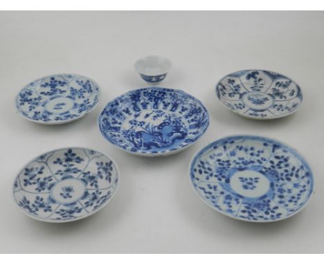 A set of five late 17th / early 18th century Kangxi period blue and white saucer plates, decorated with various panels of flo