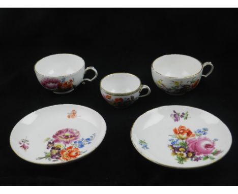 A pair of early to mid 19th century Meissen cups and saucers, decorated with summer flowers and insects, together with anothe
