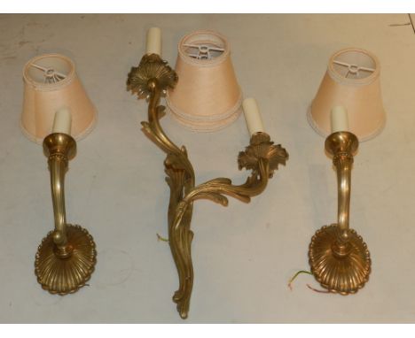 An ornate two-branch wall light, together with a pair of single branch scalloped wall lights. 