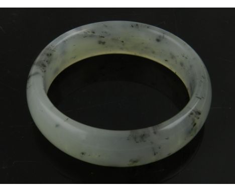 A Chinese pale green hardstone bangle.