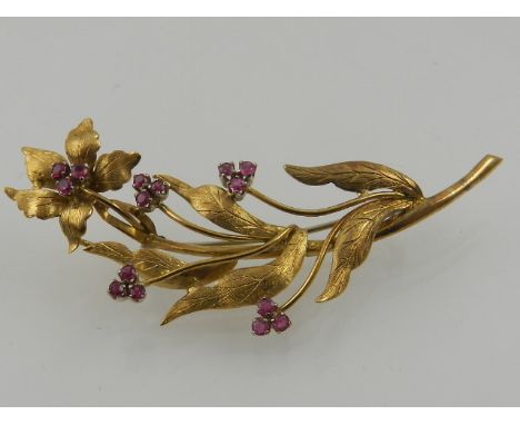 A yellow metal and ruby floral cluster brooch, stamped k.18 to verso. 