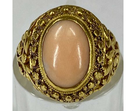 OVAL CABOCHON CORAL RING with ornate pierced and chased yellow metal mount, size F, 7gmsProvenance: private collection Conwy