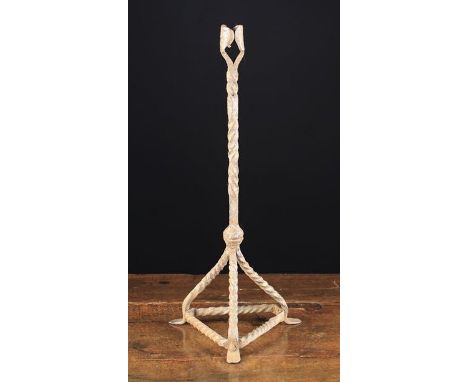 An Unusual 18th Century Wrought Iron Candlestick. The wrap-around bifoil candle socket above a wrythen stem spiralling both c