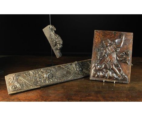 Three Carved Oak Fragments: An 18th century relief carved rail centred by a winged cherub's head flanked by fruit garlands an