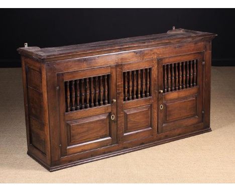 A Joined Oak Spindled Mural Cupboard in the 18th Century North Wales manner. The cupboard having two doors hung on iron loop 