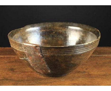 A 19th Century Treen Bowl (A/F), probably beechwood, with residual dark stain, groove turned rim band and a sheet metal patch