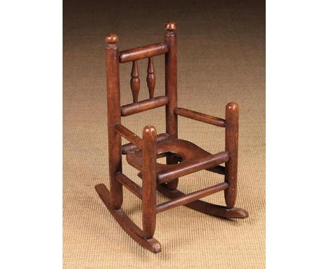 A Small 19th Century Child's Rocking Commode Armchair with pole turned components incorporating two baluster turned spindles 