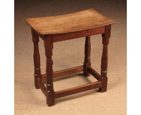 A Robert 'Mouseman' Thompson Oak Stool. The dished rectangular top raised on octagonal baluster legs united by stretchers wit