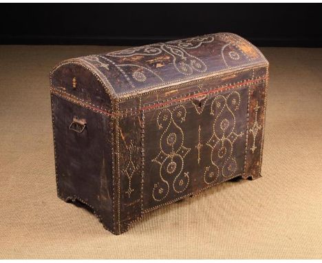 A 19th Century Dome-topped Leather-clad Trunk adorned with brass stud-work and standing on integral bracket feet. The sides f