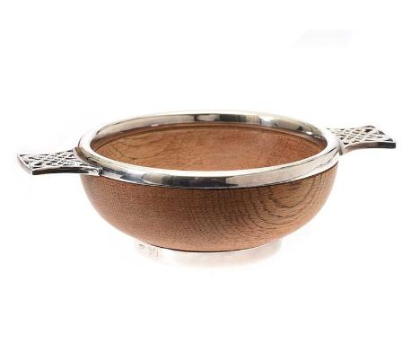TURNED OAK QUAICH, SILVER MOUNTED WITH CELTIC DESIGN HANDLES.EDINBURGH 1983.MAKER J&S.HEIGHT: 2 INCHES.DIAMETER: 4 INCHES.IN 