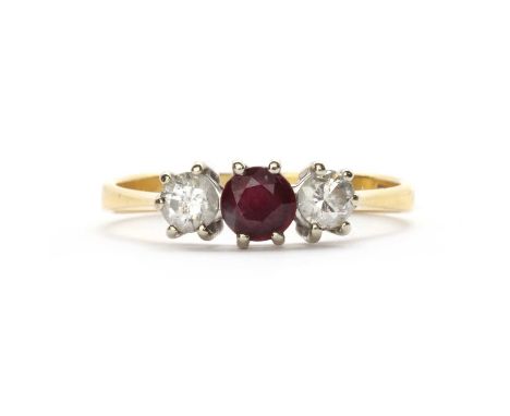 An 18ct gold ruby and diamond three stone ring,a round mixed cut ruby, to a brilliant cut diamond either side, all claw set, 