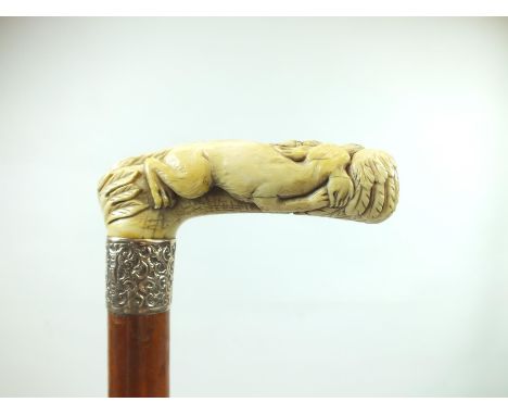 A LATE 19TH/EARLY 20TH CENTURY WALKING STICK, the ivory handle carved as an eagle fighting a dog, above indistinctly hallmark