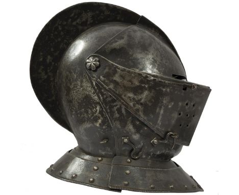 A 17TH CENTURY CLOSE-HELMET, the two-piece skull with turned and roped prominent comb, visor with one-piece sight with centra