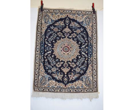 Two similar Nain rugs, central Persia, mid-20th century, the first with oval blue field, 3ft. 11in. x 2ft. 11in. 1.20m. x 0.8