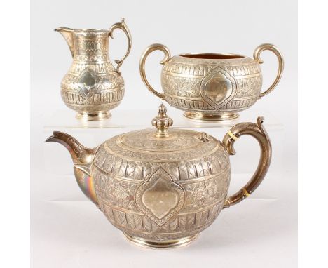 A VICTORIAN THREE PIECE INDIAN DESIGN TEA SET, comprising teapot, sugar basin and milk jug. London 1888.  GOLDSMITHS ALLIANCE