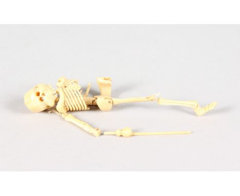A 19TH CENTURY JAPANESE CARVED BONE SKELETON NETSUKE, original box J. M. U. J. YOKOHAMA, No. 9608.