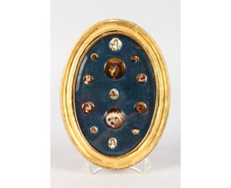 A COLLECTION OF THIRTEEN SMALL PORCELAIN AND ENAMEL PORTRAITS OF TWO LADIES, A FOX, A HORSE AND NINE DOGS in a gilt frame.