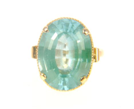 A synthetic turquoise green spinel dress ring, the oval step cut stone 20mm x 15mm, four claw set with a fine twisted rope bo