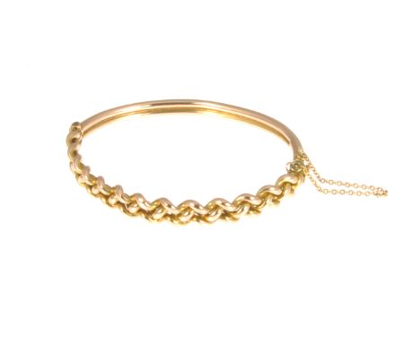 A yellow metal half hinged bangle, 7mm wide hollow woven design with a polished finish, snap stamped 9ct, approximate weight 