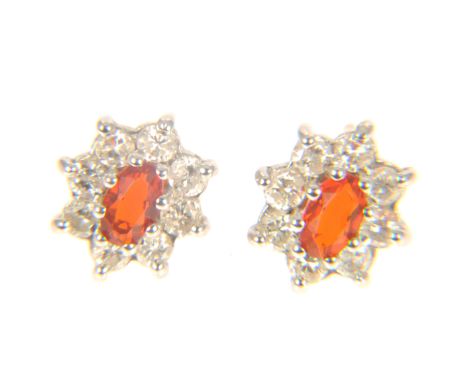 A pair of Mexican fire opal and diamond oval cluster earrings, an oval faceted opal, claw set and surrounded by eight brillia