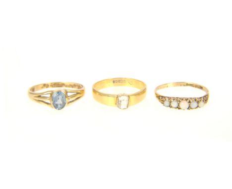 Three dress rings, a 9 carat yellow gold five stone opal ring, an 18 carat yellow gold band 3.4mm wide and set with an old cu