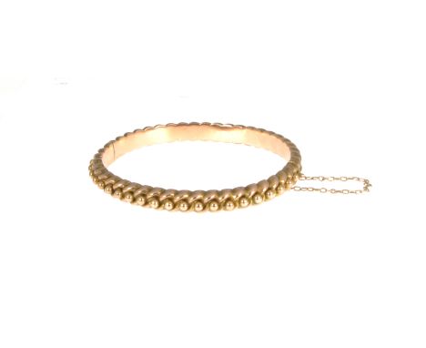 A Victorian 9 carat rose gold half hinged bangle, 6.8mm wide curb and bead design, approximate weight 10.5gms. 