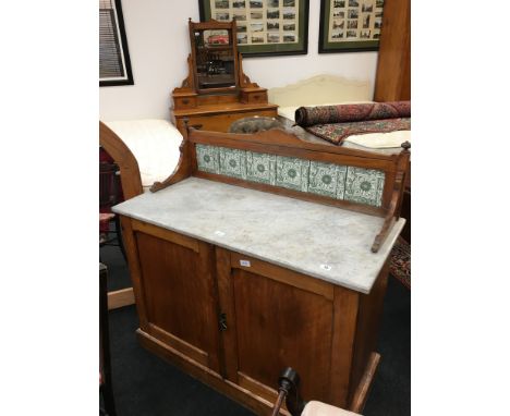 An early 20th century satin walnut washstand with marble top and tile splashback.