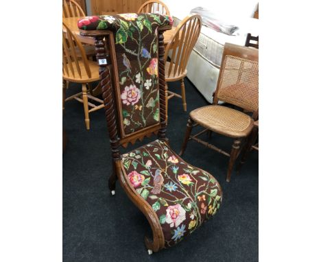 A mahogany framed prie-dieu chair with upholstered tapestry seat and back, resting on white china castors.