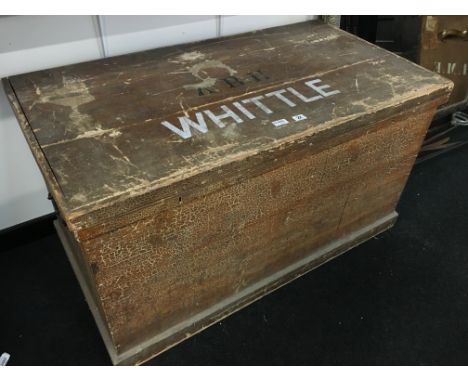 A large pine trunk with metal carrying handles.