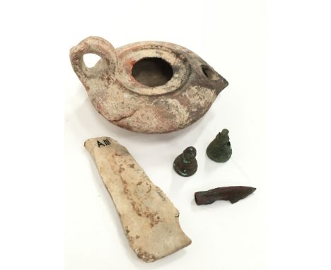 An ancient Egyptian oil lamp together with four other ancient items.