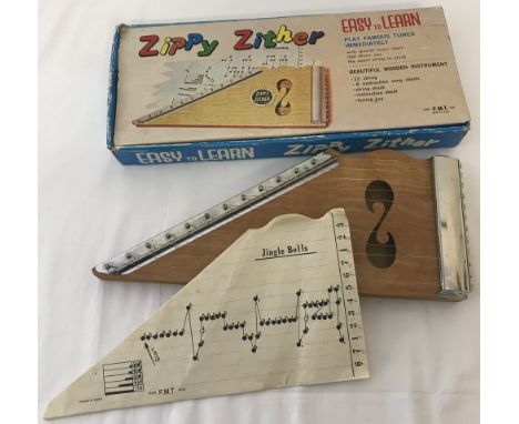 A boxed vintage "Zippy Zither" 12 string wooden instrument by F.M.T. Japan. Complete with song sheets and tuning key.